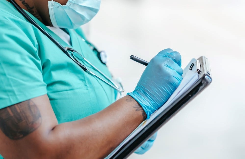 doctors note Doctor writing note on clipboard.
