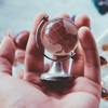 Hand holding a small glass globe