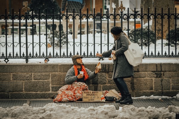 Woman giving homeless man help.