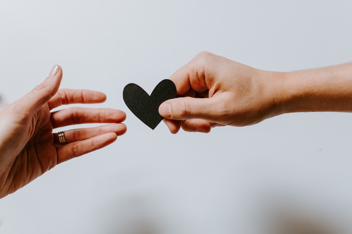 Person offering little heart to another person