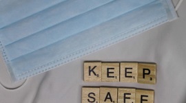 Facemask next to scrabble pieces reading 'Keep Safe'.