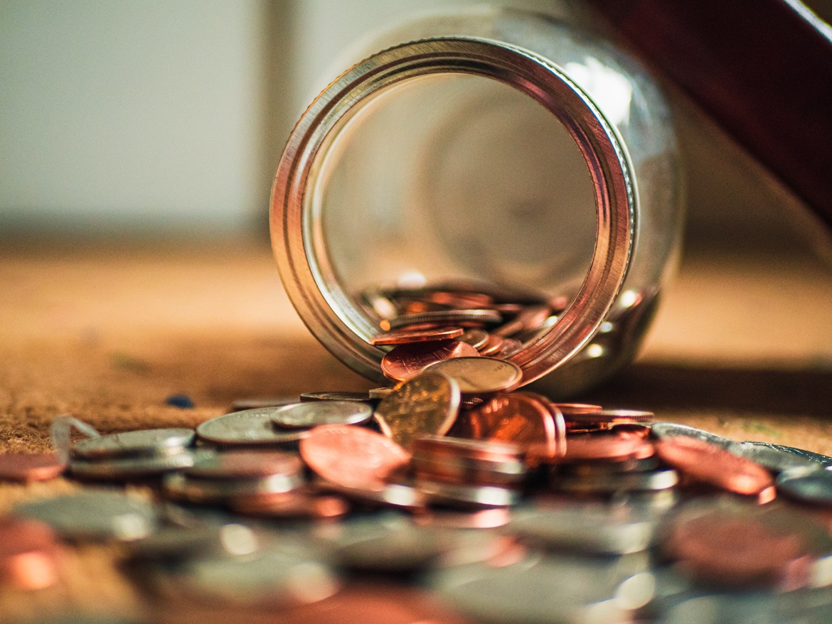 money spill Picture shows money spilling out of glass jar