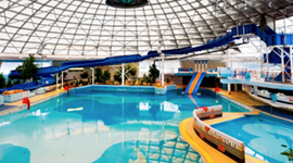Picture of inside the Oasis Leisure Centre-  showing swimming pool, slides, and inside of large dome.