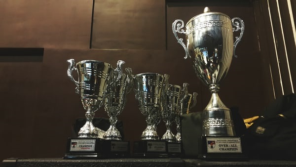 photo-1514820720301-4c4790309f46 Several trophies stood by each-other in rows.