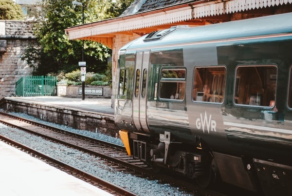 photo-1534431811882-57633c31820d A Great Western Railway Train stopped outside a station.
