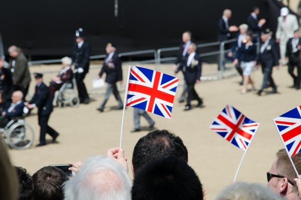 photo-1571733818896-a01d79166f2c British flags being waved in front of blurred lines of veterans.