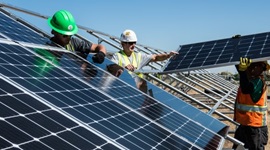 People in hi-vis wearing helmets installing solar panels.