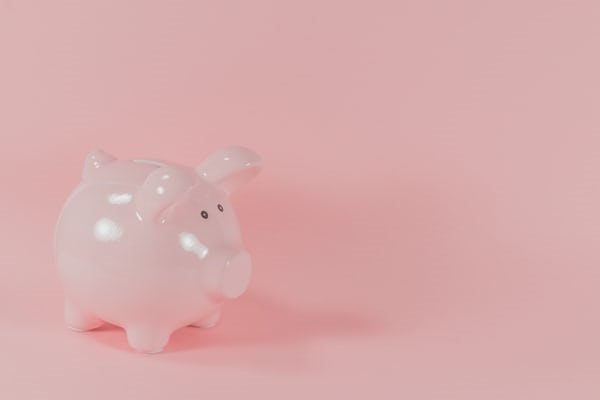 A piggy bank against a pink background.