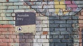 Brick wall with sign reading 'Accessible Entry'.