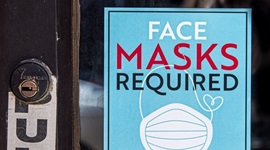 Sign on shop door reading: 'Face Masks Required prior to entry'