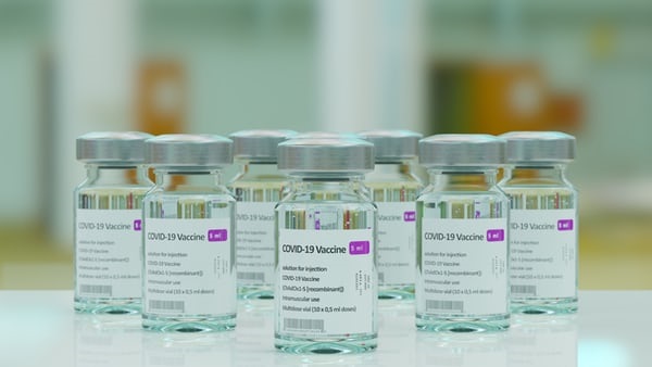 photo-1618961734760-466979ce35b0 Vials of liquid with stickers on reading 'COVID-19 Vaccine'.