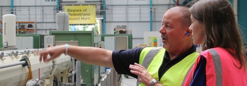 Man Pointing at Wavin's plastic forming machine