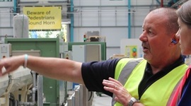 Man Pointing at Wavin's plastic forming machine